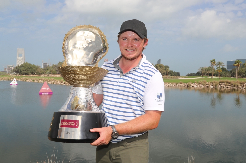 Eddie Pepperell of England poses with the winners trophy after winning the final round of the Qatar Masters golf tournament at the Doha Golf Club in Doha, on February 25, 2018. / AFP / KARIM JAAFAR
