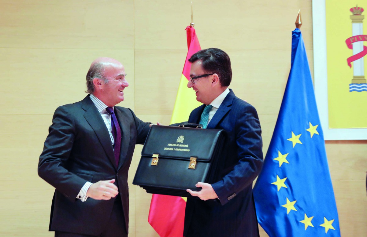 Spain's new Economy Minister Roman Escolano (R) and his predecessor Luis de Guindos smile during a taking over ceremony at Economy Ministry in Madrid, Spain, March 9, 2018. Reuters/Sergio Perez