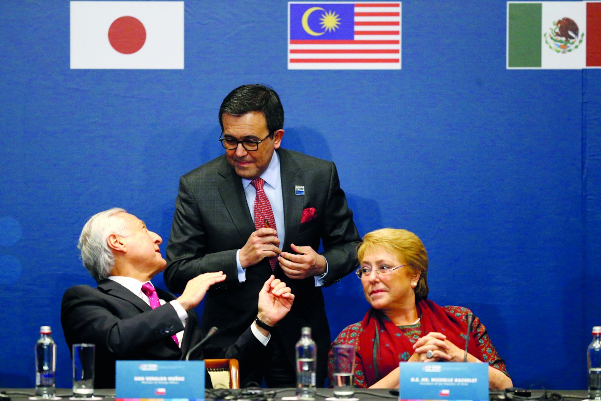 Chile's Foreign Minister Heraldo Munoz talks to Mexico's Secretary of Economy Ildefonso Guajardo Villarreal next to Chile's President Michelle Bachelet, during the signing agreement ceremony for the Trans-Pacific Partnership (TPP) trade deal, in Santiago,