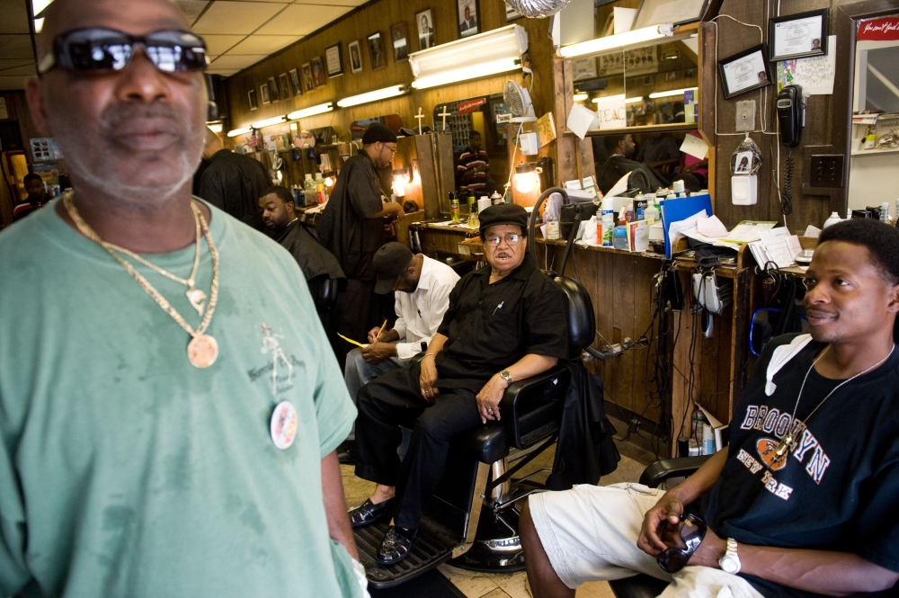 In this file photo taken on July 11, 2008 Nurney Mason (C) of Washington, DC, sits alongside customers in his son's barbershop at Mason's Hair Gallery, a barbershop and hair salon, in Washington,DC. Black barbershops are known as places to gather, sociali