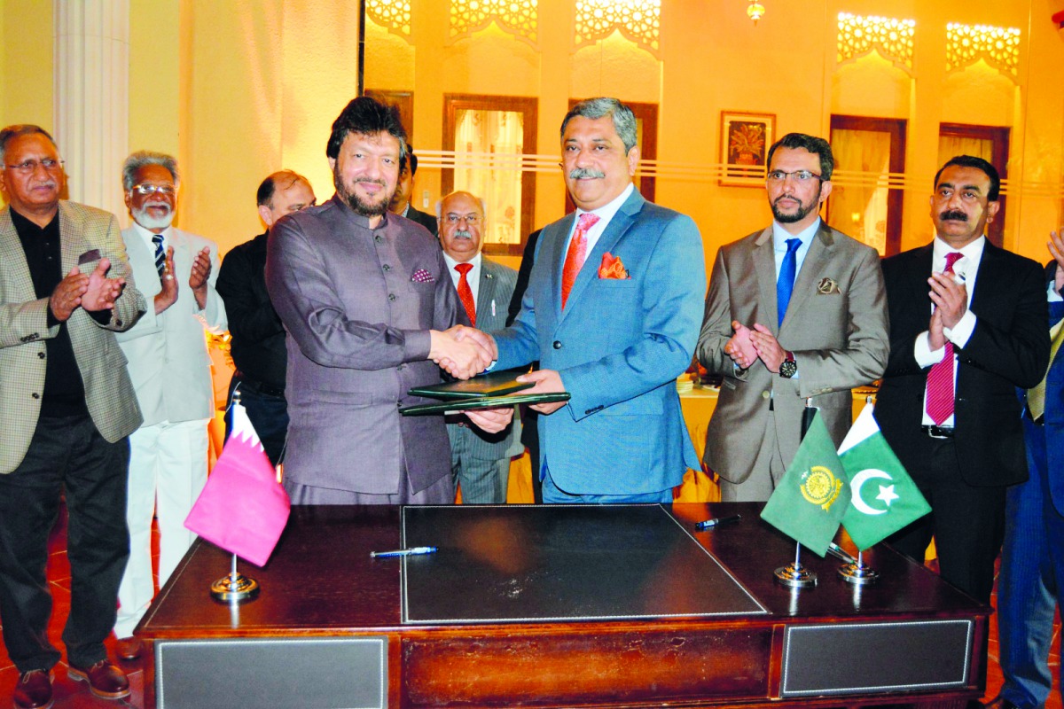 Mohammad Idrees Anwar (left), President of Pakistan Business Forum Doha; and Zahid Latif Khan, President of Rawalpindi Chamber of Commerce & Industry; shake hands after signing of a formal MoU for mutual cooperation and promoting bilateral trade, investme