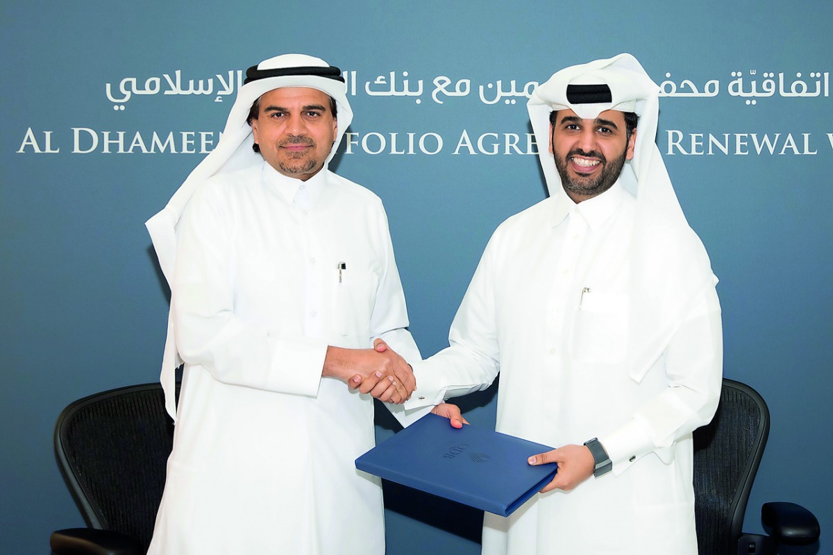 Abdulaziz bin Nasser Al Khalifa (right), CEO of QDB; and Dr Abdulbasit Ahmad Al Shaibei, QIIB Chief Executive Officer, shake hands after signing the deal at the QDB head office, yesterday.