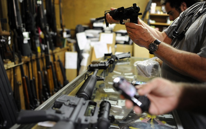 Customers look over the last two AR-15 style rifles for sale inside the Bullet Hole gun shop in Sarasota, Florida. (Reuters) 