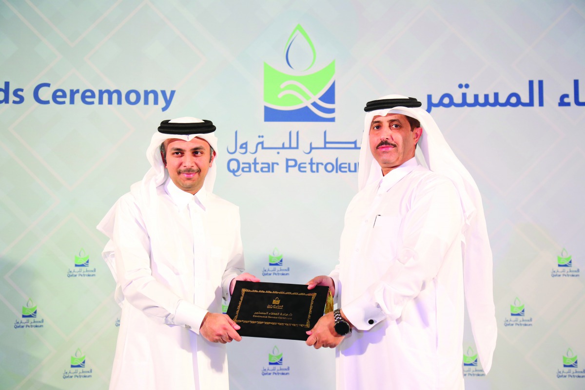 Abdulaziz Mohammed Al Mannai (left), Executive Vice-President, Human Capital, QP, honouring a staff for long service.