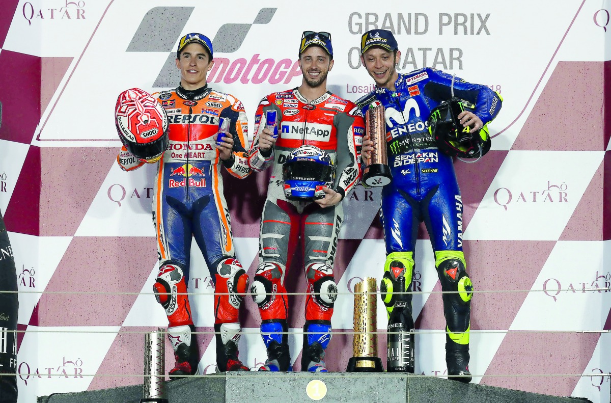 First-placed Ducati Team rider Andrea Dovizioso of Italy (centre), second-placed Repsol Honda rider Marc Marquez of Spain (left), and third-placed Movistar Yamaha rider Valentino Rossi of Italy pose on the podium yesterday. Pictures: Kammutty Vp/The Penin