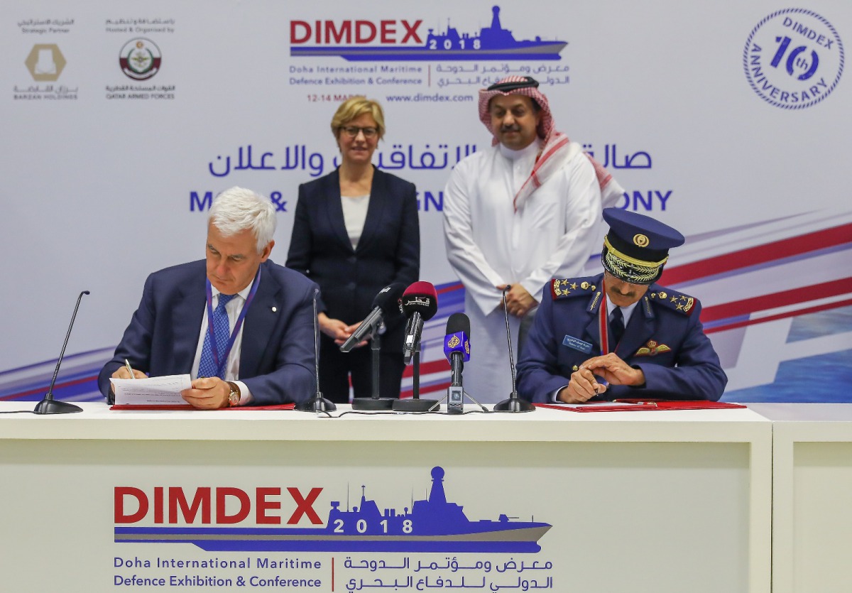 Deputy Prime Minister and Minister of State for Defence Affairs H E Dr Khalid bin Mohamed Al Attiyah (right, standing) and Italian Minister of Defence, Roberta Pinotti (left, standing) witnessing the signing of an agreement between Qatar Air Force and Ita