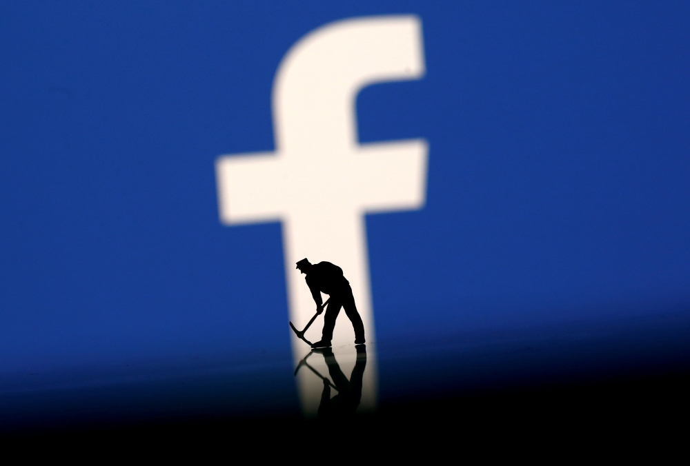 FILE PHOTO: A figurine is seen in front of the Facebook logo in this illustration taken, March 20, 2018. REUTERS/Dado Ruvic/Illustration/File Photo