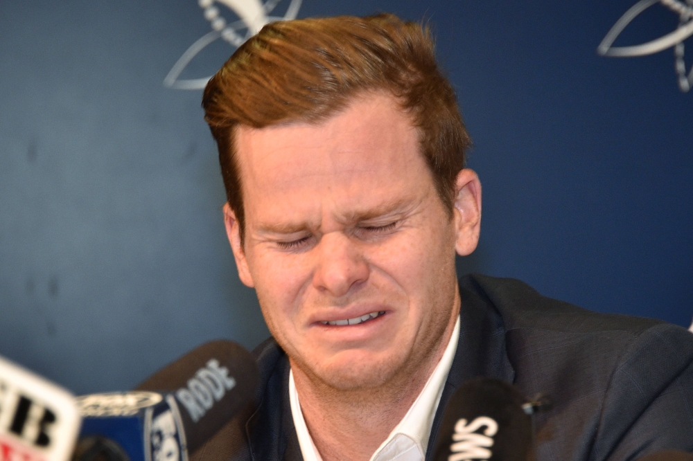 Cricketer Steve Smith reacts at a press conference at the airport in Sydney on March 29, 2018, after returning from South Africa.  AFP / PETER PARKS
