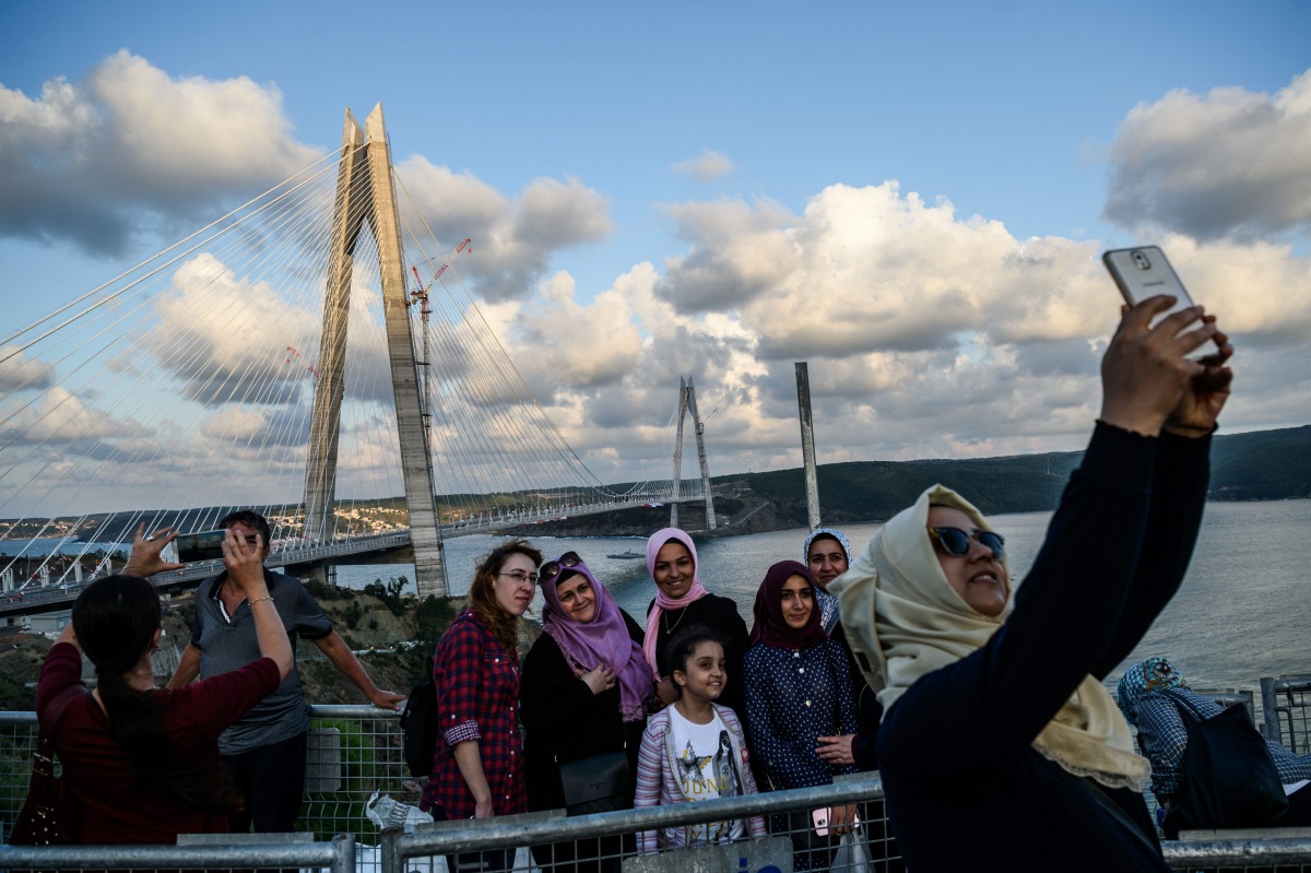 People take selfies as they pose next to the Yavuz Sultan Selim bridge on August 26, 2016 in Istanbul during the inauguration of the bridge (AFP) 