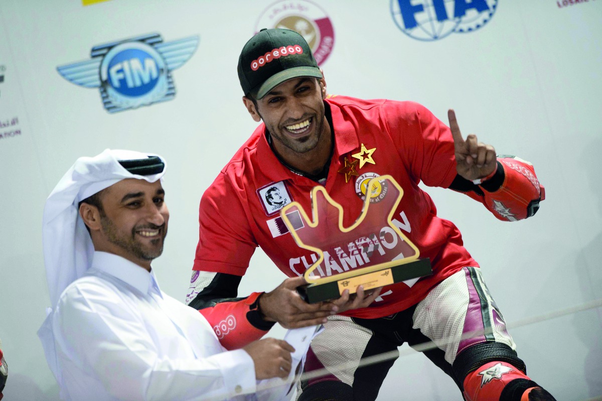 Saeed Al Sulaiti receives the winner’s trophy from Abdulrazak Al Kuwari, Secretary General of QMMF, at Losail International Circuit. BELOW: Al Sulaiti is seen in action while racing against Mashel Al Naimi and Nasser Al Malki. 