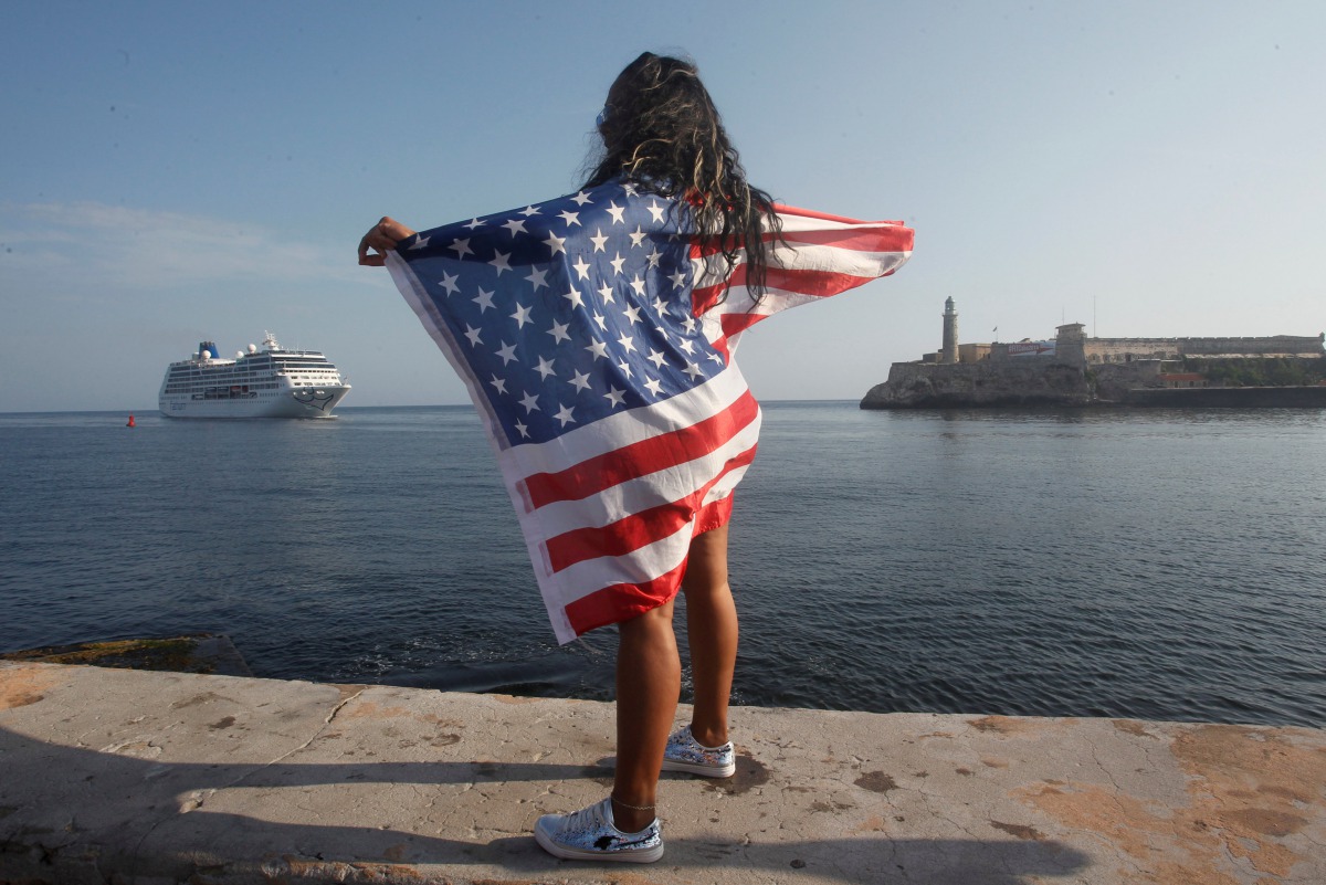 A woman with a US flags looks at the arrival of US Carnival cruise ship Adonia at the Havana bay,  May 2, 2016. Reuters
