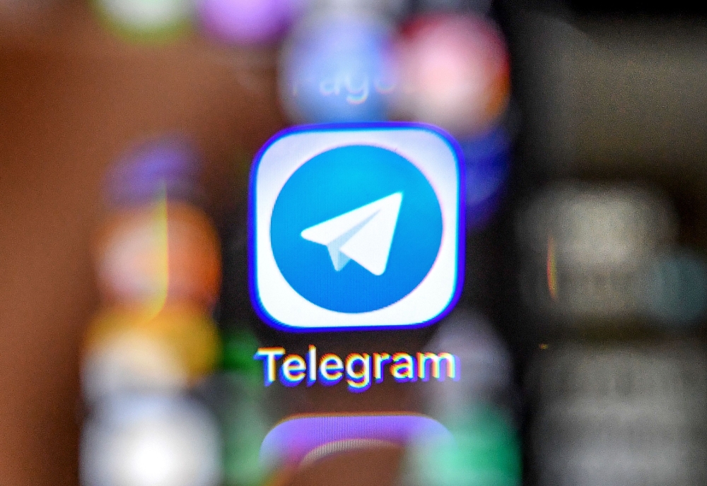 An illustration picture taken through a magnifying glass on April 17, 2018 in Moscow shows the icon of the popular messaging app Telegram on a smart phone screen. AFP / Yuri KADOBNOV