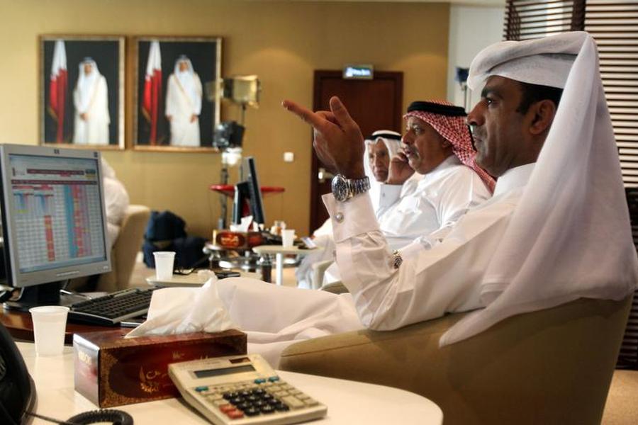 Traders monitor screens displaying stock information at Qatar Stock Exchange in Doha in this file photo of November 9, 2016. (Reuters/  Naseem Zeitoon) 
