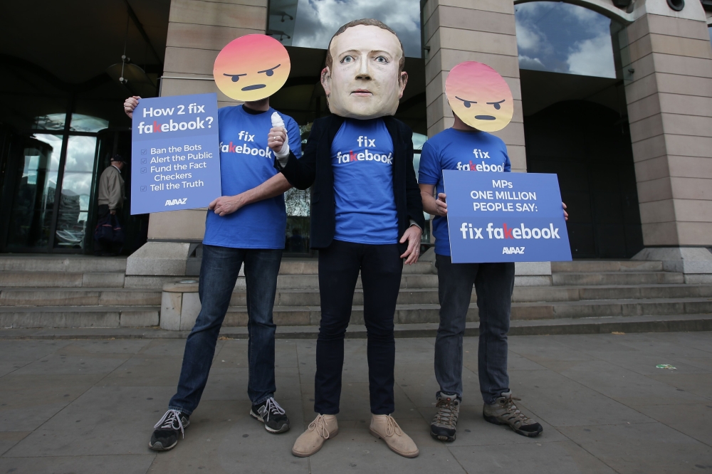 Protestors from the pressure group Avaaz demonstrate outside Portcullis house where Facebook's Chief Technology Officer Mike Schroepfer is to be questioned by members of parliament in London on April 26, 2018. / AFP / Daniel LEAL-OLIVAS