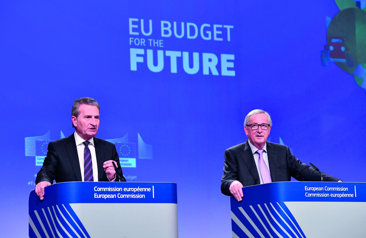 EU Commissioner for the Budget Gunther Oettinger (L) is watched by European Commission President Jean-Claude Juncker (R) as he addresses a press conference to present the EU's next long-term budget, at the European Commission in Brussels, on May 2, 2018. 