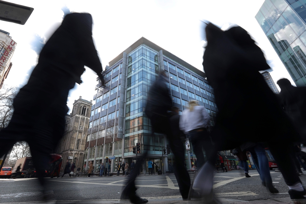 Pedestrians pass the shared building which houses the offices of Cambridge Analytica in central London on March 21, 2018. (AFP / Daniel Leal-Olivas) 