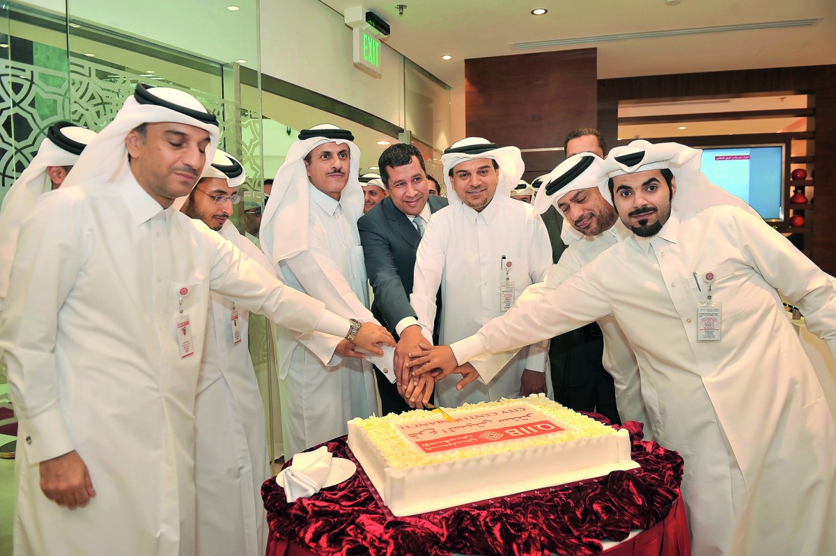 Sheikh Dr Khalid bin Thani bin Abdullah Al Thani (third left), Chairman and Managing Director of QIIB; Dr Abdulbasit Ahmed Al Shaibei (third right), CEO of QIIB; and Jamal Abdallah Al Jamal (left), QIIB’s Deputy CEO cutting the celebration cake with other