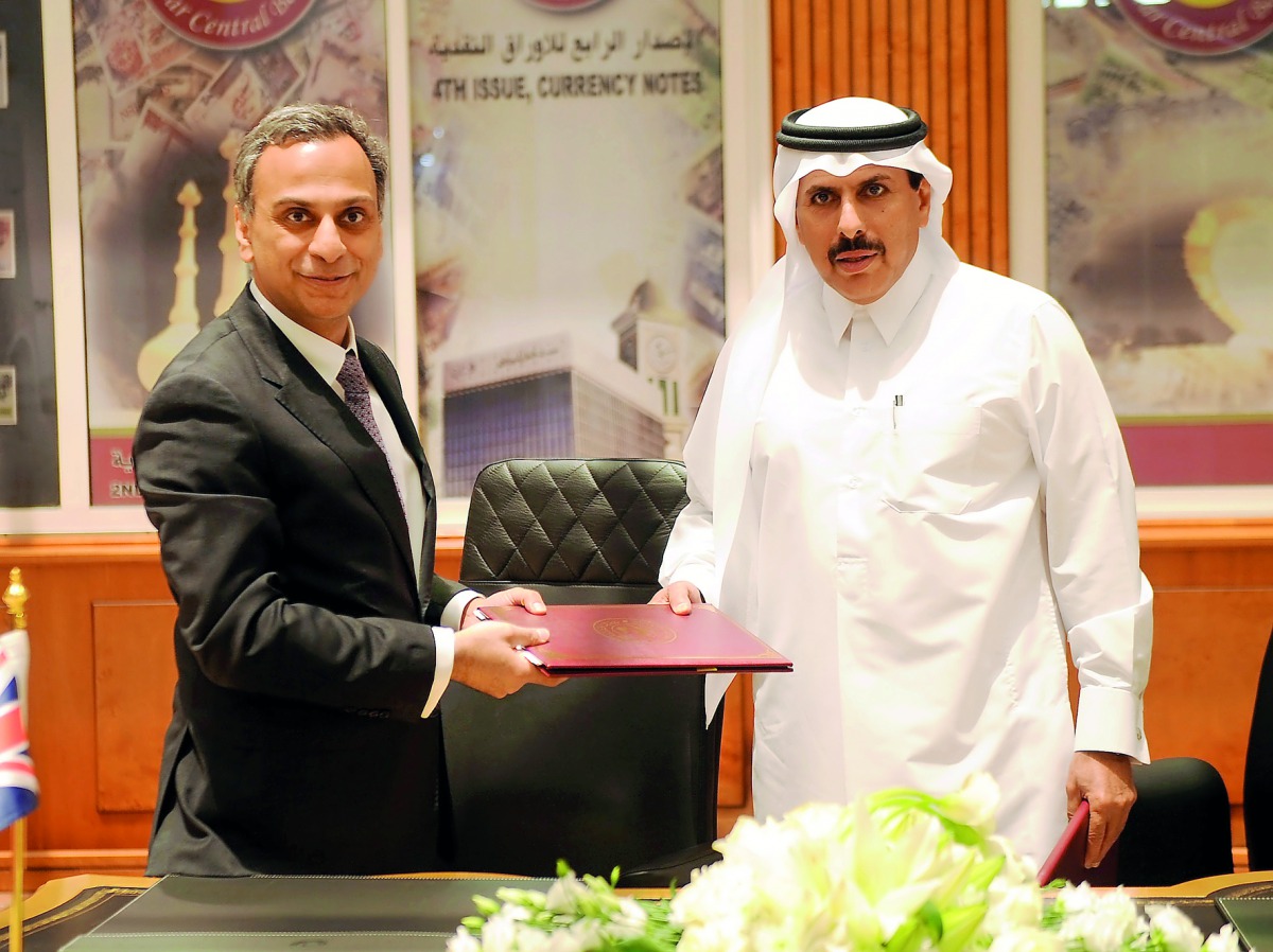 H E Sheikh Abdullah bin Saoud Al Thani (right), QCB Governor, with Ajay Sharma, British Ambassador to Qatar, during the signing ceremony, yesterday. Pic: Abdul Basit/The Peninsula