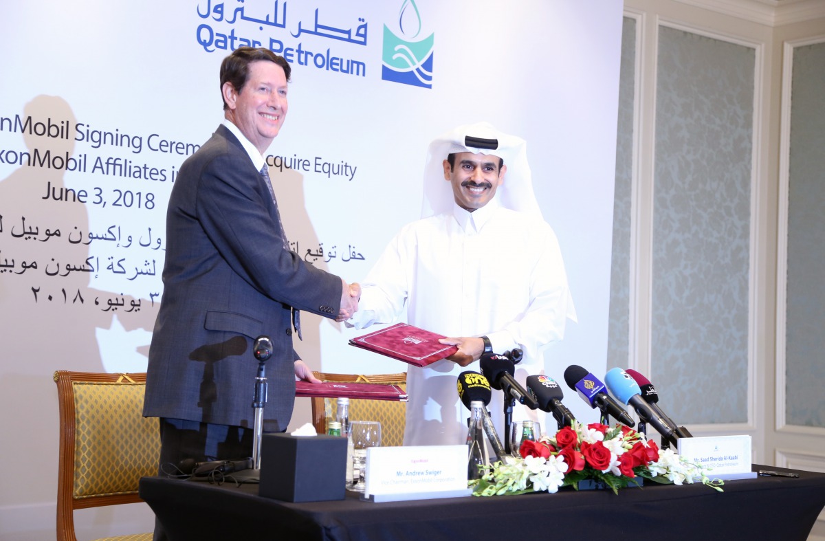 Saad Sherida Al Kaabi, President and CEO of Qatar Petroleum, and Andrew P Swiger, Senior Vice-President and Principal Financial Officer of ExxonMobil Corporation, exchanging the signed documents in Doha yesterday. Pic: Baher Amin / The Peninsula