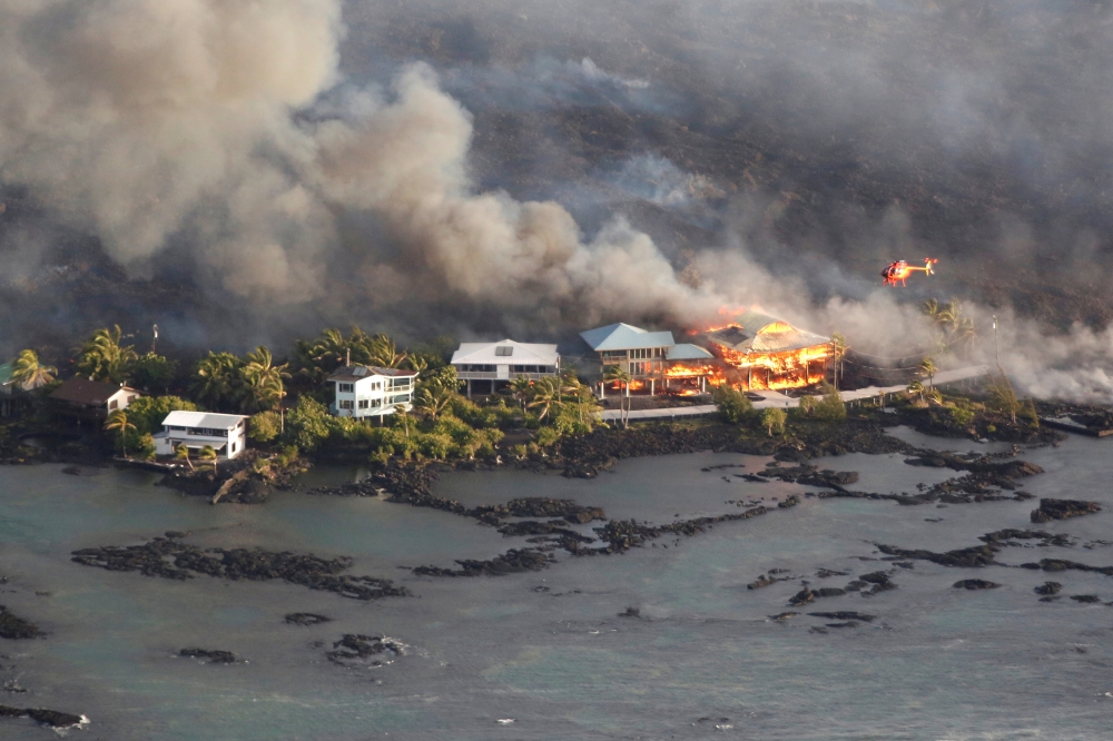Lava destroys homes in the Kapoho area, east of Pahoa, during ongoing eruptions of the Kilauea Volcano in Hawaii, U.S., June 5, 2018. REUTERS/Terray Sylvester