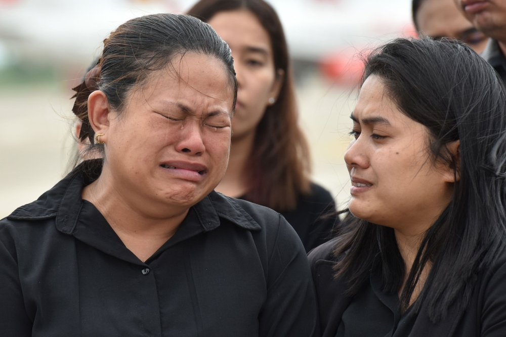 Family members grieve during arrival honors for the remains of Saman Gunan, a former Royal Thai Navy SEAL who died in an accident in Tham Luang cave in a rescue mission for the trapped 12 boys and their coach, at a military base in Chon Buri province on J