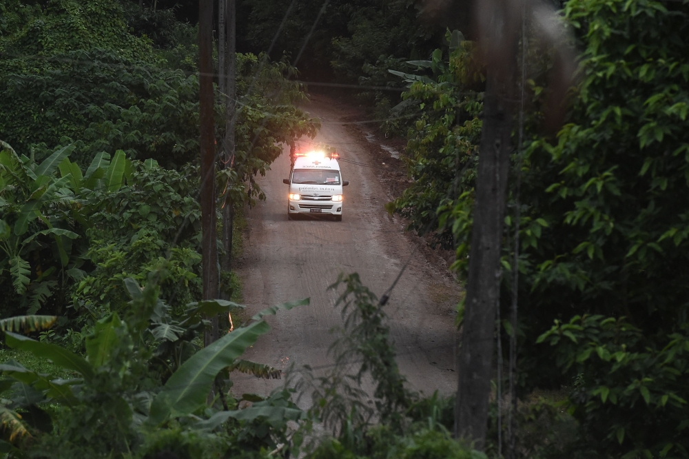 An ambulance leave the Tham Luang cave area as divers evacuated some of the 12 boys and their coach trapped at the cave in Khun Nam Nang Non Forest Park in the Mae Sai district of Chiang Rai province on July 8, 2018. (AFP / LILLIAN SUWANRUMPHA)