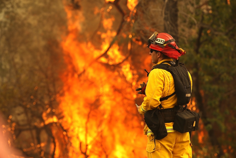 A Redding firefighter looks on as the Carr Fire moves through the area on July 28, 2018 in Redding, California. Justin Sullivan/Getty Images/AFP
