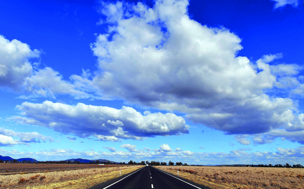 This photo taken on August 7, 2018 shows a road dividing two dry farm paddocks in the drought-hit area of Quirindi in New South Wales. AFP / Saeed Khan  