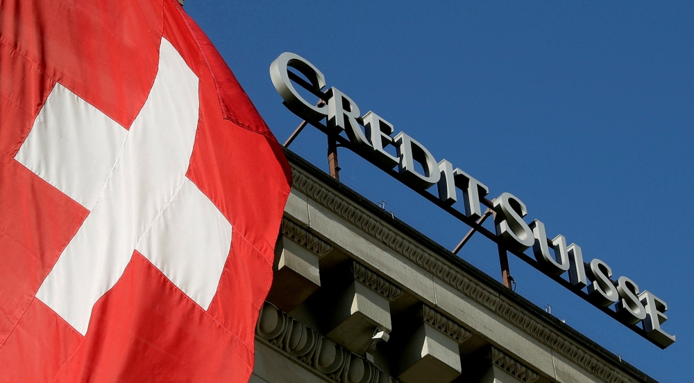 Switzerland's national flag flies next to the logo of Swiss bank Credit Suisse at a branch office in Luzern, Switzerland October 19, 2017. Reuters/Arnd Wiegmann
