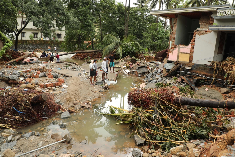 In this file photo taken on August 10, 2018 residents look at houses destroyed by flood waters at Kannappankundu in Kozhikode, in the Indian state of Kerala on August 10, 2018.  AFP 