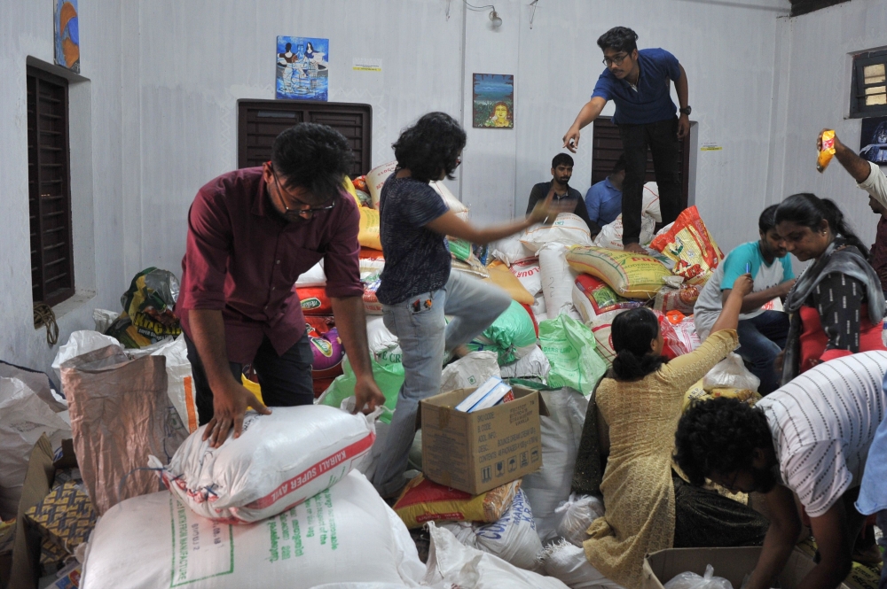Volunteering members of the public help sort flood relief material at the District Tourism Promotion Council (DTPC), in Kozhikode district, about 385 km north of Trivandrum, in the south Indian state of Kerala, on August 17, 2018.  AFP / Manjunath Kiran