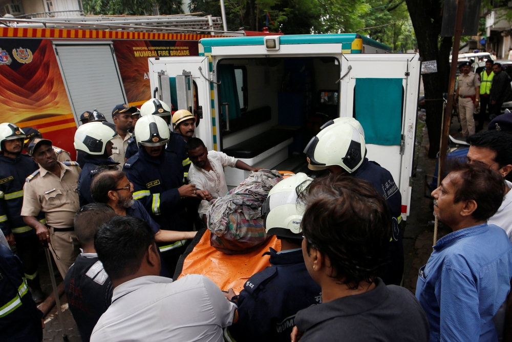  Firefighters carry the body of a victim killed in a fire at a residential building in Mumbai, India, August 22, 2018. REUTERS/Francis Mascarenhas 