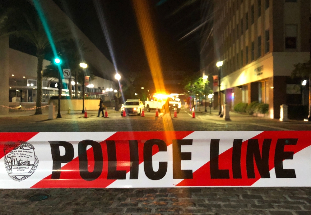 This photo shows a police car behind police tape blocking a street leading to the Jacksonville Landing area in downtown Jacksonville, Florida, August 26, 2018, where two people were killed and 11 others wounded. AFP / Gianrigo Marletta 