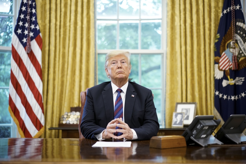FILE PHOTO: US President Donald Trump listens during a phone conversation with Mexico's President Enrique Pena Nieto on trade in the Oval Office of the White House in Washington, DC.   AFP / MANDEL NGAN