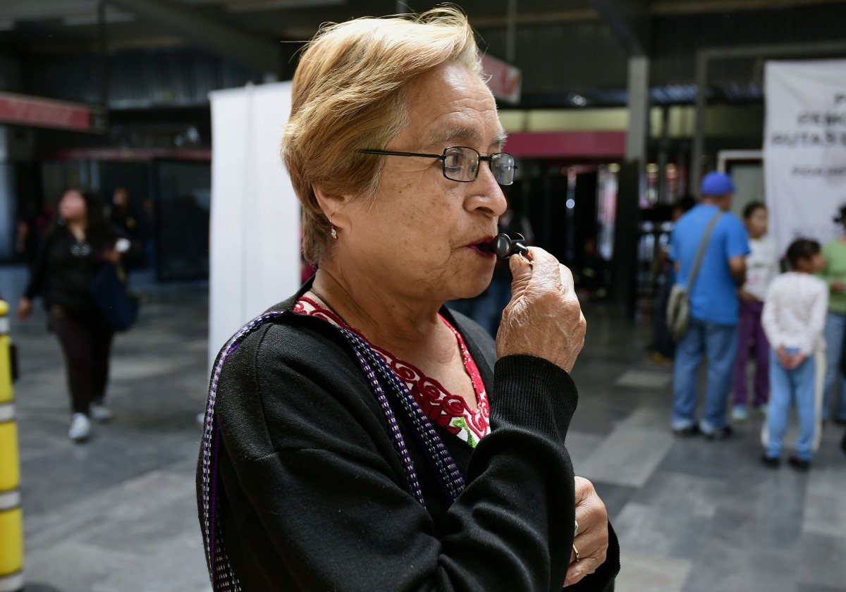 A woman tries a whistle at the Pantitlan Metro Station in Mexico City during a campaign aimed at preventing sexual abuse on July 06, 2016. AFP/Alfredo Estrella