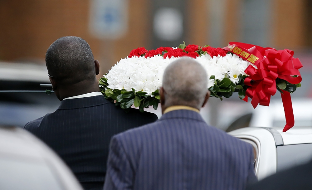 A person carrying a wreath of flowers walks through the parking lot at the Greenville Avenue Church of Christ for the funeral service for Botham Shem Jean on September 13, 2018 in Richardson, Texas. Stewart F. House/Getty Images/AFP 