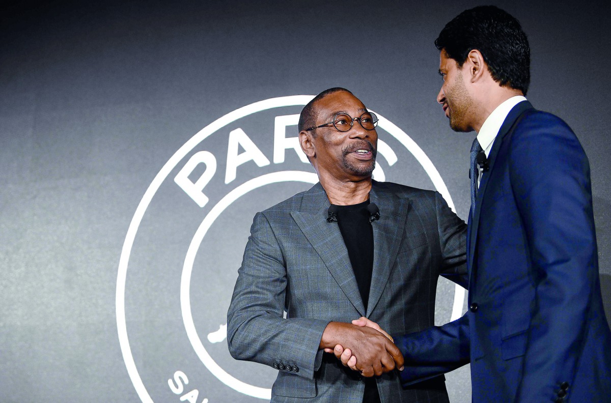 The Jordan Brand's president Larry Miller (L) shakes hands with Paris Saint-Germain's Qatari president Nasser Al-Khelaifi at the Parc des Princes stadium in Paris on September 13, 2018 during the presentation of PSG's UEFA Champions League new jerseys mad