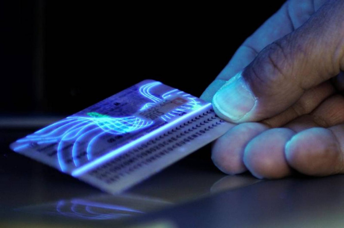 A Swiss Customs officer checks an identity card with UV light at the Swiss-Italian border station in Stabio, March 2, 2011. Reuters/Fiorenzo Maffi