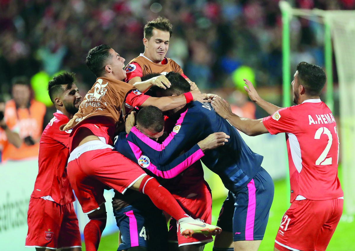 Perspolis’ players celebrate after scoring during the AFC Champions League quarter-final match against Al Duhail SC at the Azadi Stadium in the Iranian capital Tehran, yesterday.