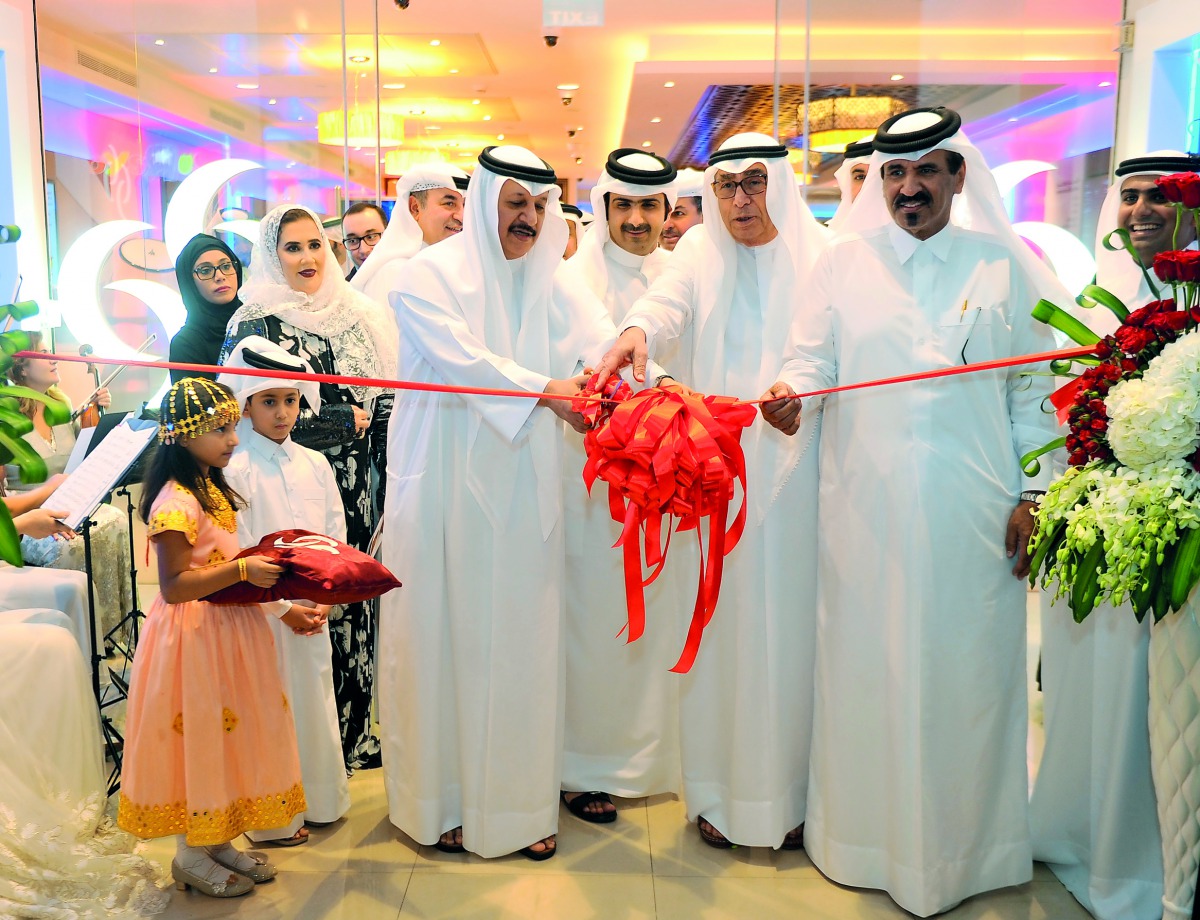 Sheikh Abdullah bin Ali bin Jabor Al Thani, (left) Chairman, Commercial Bank of Qatar; cutting a ribbon with Hussain Ibrahim Al Fardan, Vice-Chairman; and Mohamed bin Ahmed bin Towar  Al Kuwari (right) Vice-Chairman, Qatar Chamber; and other guests at the