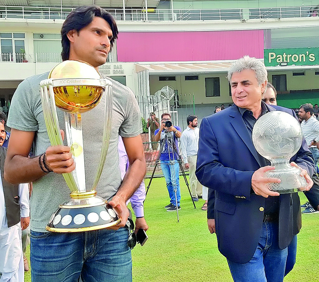 Pakistan pacer Muhammad Irfan (left) holds the World Cup 2019 trophy as it arrived in Lahore, while former Pakistan cricketer and PCB’s Director International Cricket Zakir holds the 1992 World Cup trophy which was also put on display at Gaddafi Stadium  