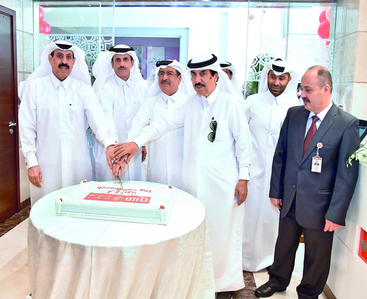 QIIB Chairman and Managing Director Sheikh Dr Khalid bin Thani bin Abdullah Al Thani (second left) along with other board members cutting a ceremonial cake marking the opening of QIIB’s The Mall branch, yesterday.