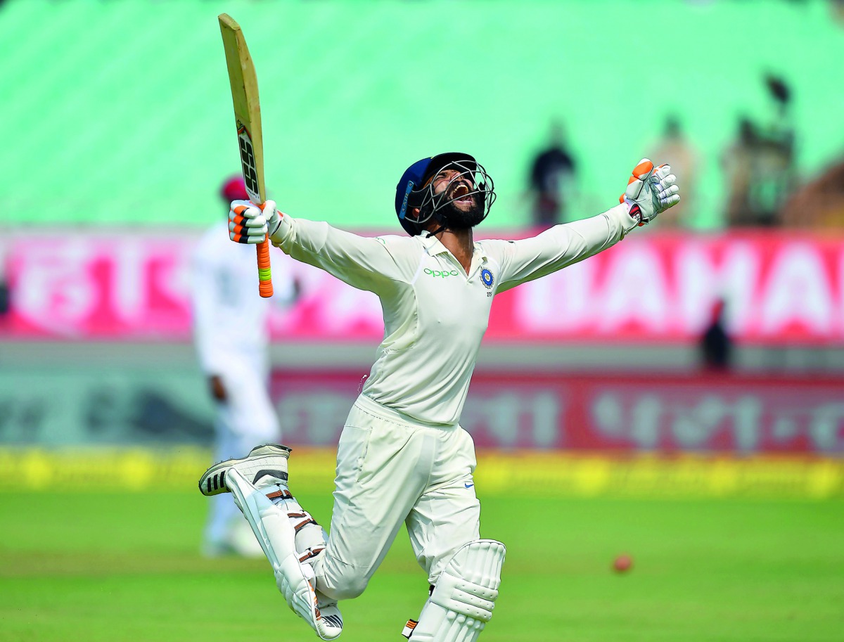 India's Ravindra Jadeja celebrates after reaching his century (100 runs) during the second day's play of the first Test cricket match between India and West Indies at the Saurashtra Cricket Association stadium in Rajkot on October 5, 2018. AFP / Indranil 
