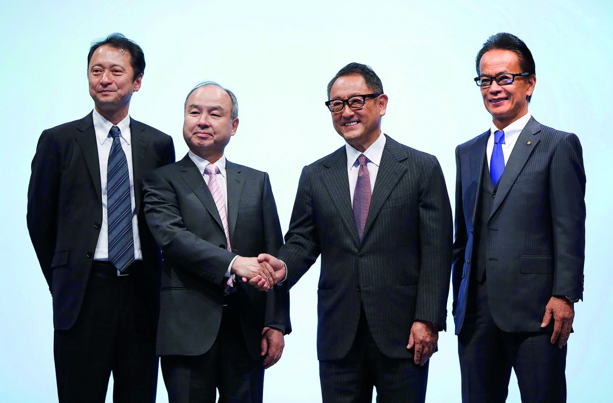 Toyota Motor Corp President Akio Toyoda and Executive Vice President Shigeki Tomoyama poses for a photograph with SoftBank Group Corp Chairman and CEO Masayoshi Son and SoftBank Corp Representative Director and CTO Junichi Miyakawa during their joint news