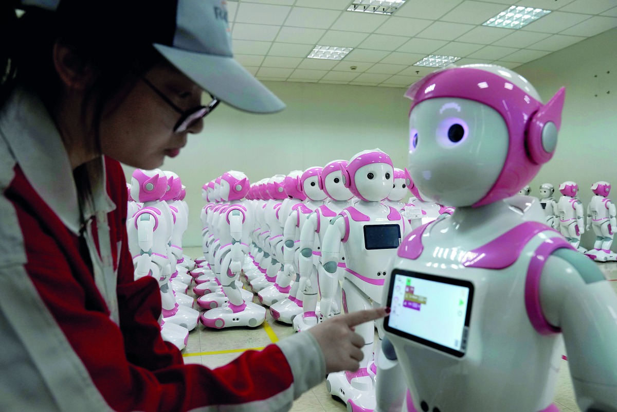 FILE PHOTO: A worker puts finishing touches to an iPal social robot, designed by AvatarMind, at an assembly plant in Suzhou, Jiangsu province, China July 4, 2018. Reuters/Aly Song
