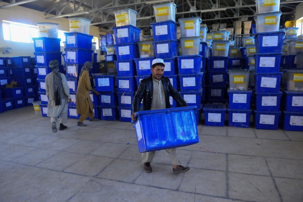 Afghan employees of the Independent Election Commission (IEC) carry ballot boxes at a warehouse in Herat province on October 17, 2018.  AFP / HOSHANG HASHIMI