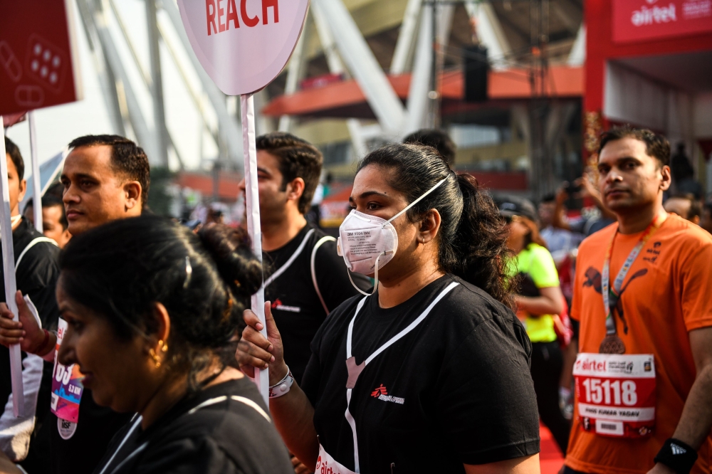 An Indian runner wears a face mask as she participates in the New Delhi half marathon in the Indian capital on October 21, 2018.  / AFP / CHANDAN KHANNA 