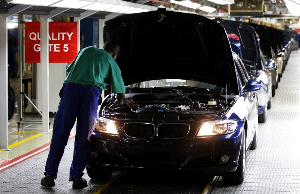 FILE PHOTO: A worker inspects cars at BMW's manufacturing plant in Rosslyn, outside Pretoria, September 13, 2010. REUTERS/Siphiwe Sibeko/File Photo