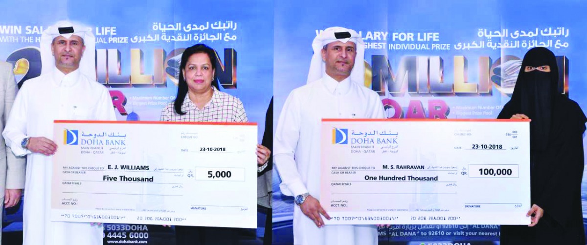 Al Dana savings scheme winners receiving the prize cheques.