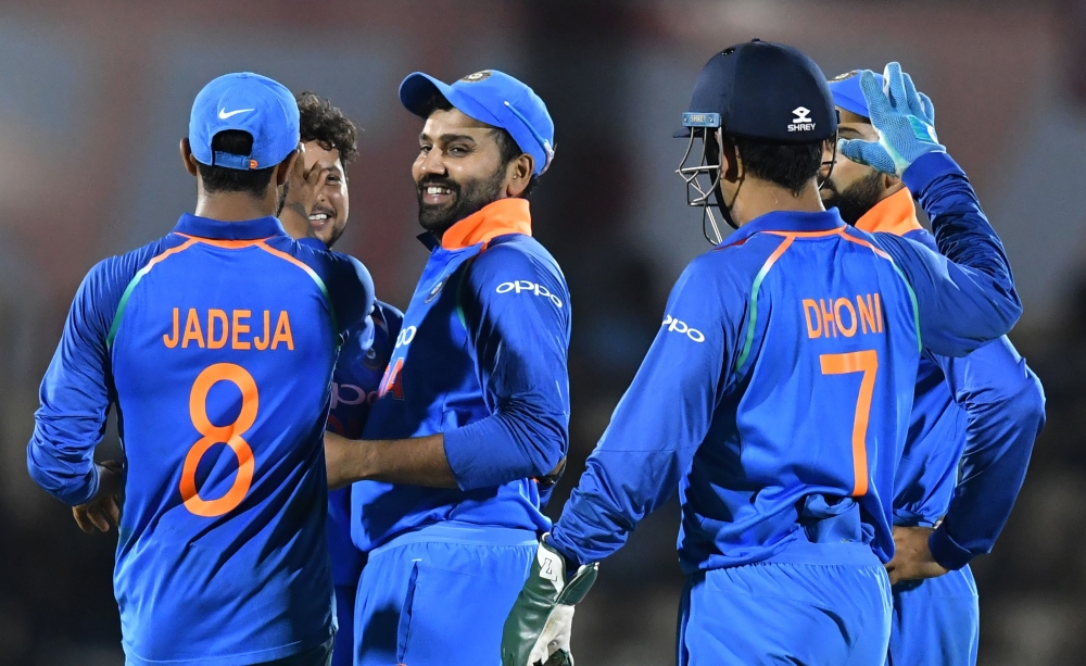 India cricketer Rohit Sharma (C) celebrates with teammates after taking the catch to dismiss West Indies batsman Ashley Nurse during the fourth one day international (ODI) cricket match between India and West Indies at the Brabourne Stadium in Mumbai on O